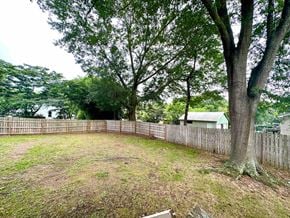 Greenville house for rent - a fenced in backyard with trees and a fence