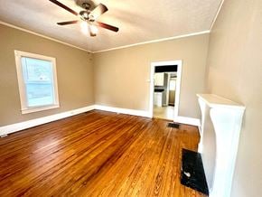 Greenville house for rent - an empty living room with wood floors and a ceiling fan