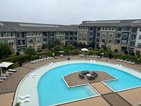 Plano house for rent - an aerial view of a large swimming pool in front of an apartment building