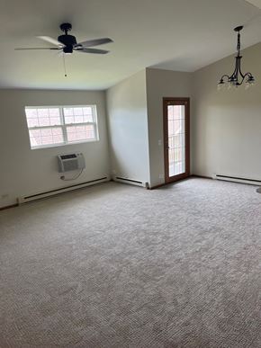Round Lake Beach apartment for rent - an empty living room with a ceiling fan and a window