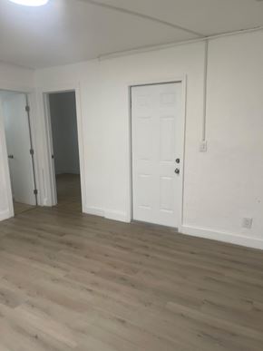 Fort Myers apartment for rent - A room with a white door and a wooden floor.