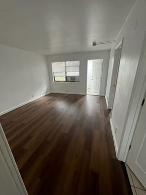 Fort Myers apartment for rent - A room with wooden floors and white walls.