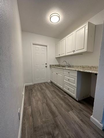 Fort Myers apartment for rent - A kitchen with white cabinets and a wooden floor.