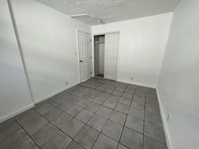 Fort Myers apartment for rent - A room with white walls and tile flooring with two doors.
