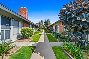 Stanton apartment for rent - a sidewalk in front of a building with plants and trees