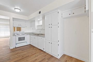 Stanton apartment for rent - a white kitchen with white cabinets and a wood floor