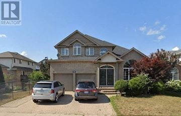 Guelph house for rent - a house with two cars parked in front of it