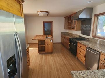 Dallas house for rent - a kitchen with wooden floors and stainless steel appliances