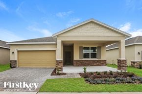 Kissimmee house for rent - a beige house with a driveway and a garage door