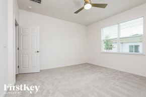 Kissimmee house for rent - a bedroom with a ceiling fan and a window