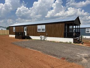Shawnee house for rent - A small wooden building with a metal roof and a porch.