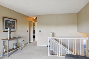 Hudson house for rent - a living room with a staircase and a painting on the wall