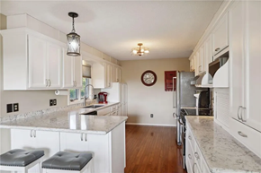 Hudson house for rent - a kitchen with white cabinets and marble counter tops