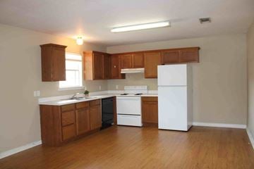 Hattiesburg apartment for rent - A kitchen with wooden cabinets and white appliances.
