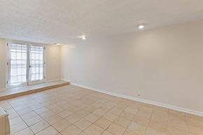 Nashville apartment for rent - A spacious room with tiled flooring and a window with blinds.