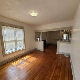 Louisville apartment for rent - an empty living room with a wood floor and a window