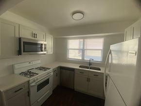 Louisville apartment for rent - A small kitchen with white appliances and cabinets.