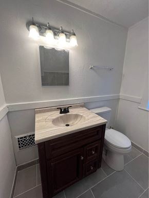 Louisville apartment for rent - a bathroom with a toilet and a sink and a mirror