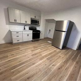 Louisville apartment for rent - a kitchen with white cabinets and a stainless steel refrigerator