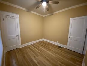 Louisville house for rent - A room with a ceiling fan and wooden flooring.
