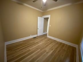 Louisville house for rent - A room with a wooden floor and a white door.