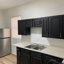 Louisville apartment for rent - A kitchen with black cabinets and a stainless steel refrigerator.