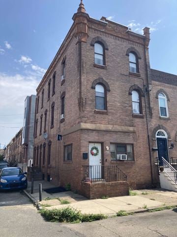 Philadelphia apartment for rent - A blue car is parked on the sidewalk in front of a brick building.