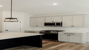 Hudson house for rent - a white kitchen with black appliances and white cabinets