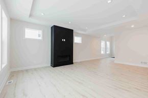 Hugo house for rent - an empty living room with a black wardrobe in the middle