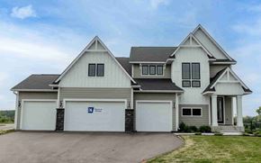 Hugo house for rent - a large white house with garage doors and a driveway
