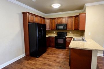 Bowling Green apartment for rent - A kitchen with wooden cabinets and black appliances.
