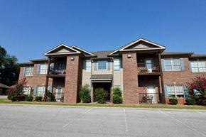 Bowling Green apartment for rent - A large brick apartment building with a parking lot in front.