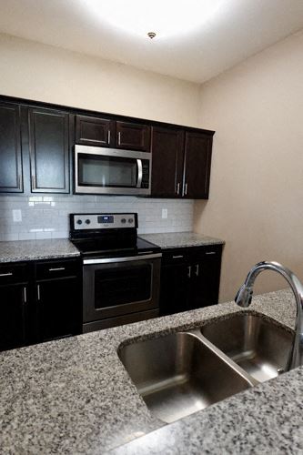 Bowling Green apartment for rent - A kitchen with black cabinets and granite countertops.
