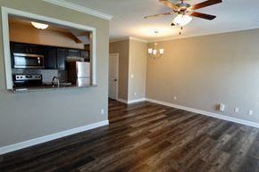 Bowling Green apartment for rent - A room with a ceiling fan and a kitchen area in the background.