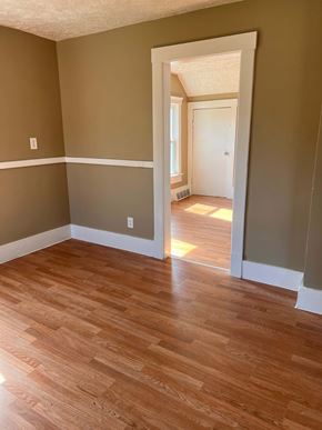 Cleveland apartment for rent - a living room with wood flooring and a hallway with a door open