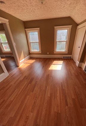 Cleveland apartment for rent - an empty living room with wooden floors and three windows