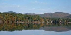Manchester apartment for rent - A serene lake surrounded by mountains and trees.