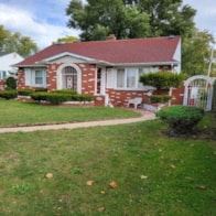 Gary house for rent - a small brick house with a red roof and a green yard