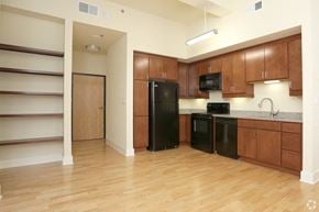 Richmond apartment for rent - a kitchen with black appliances and wooden cabinets