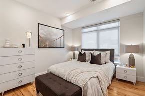 Newark apartment for rent - A bedroom with a large bed, a dresser, and a painting on the wall.