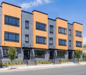 Newark apartment for rent - A row of modern townhouses with orange and grey exteriors.