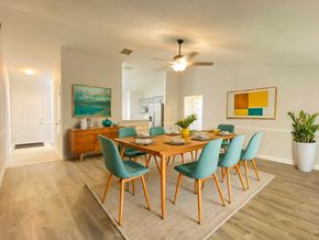 Orlando house for rent - A dining room with a wooden table and green chairs.