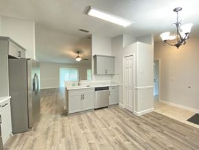 Orlando house for rent - A kitchen with white cabinets and a stainless steel refrigerator.