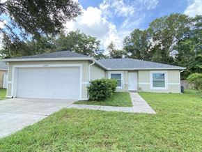 Orlando house for rent - A house with a white garage door and a small front yard.