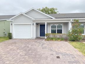 St Cloud house for rent - a white house with a blue door and a brick driveway