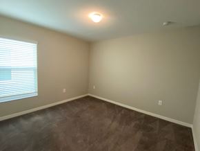 St Cloud house for rent - a empty room with a large window and brown carpet