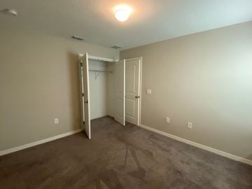 St Cloud house for rent - a bedroom with a carpeted floor and a door to a closet