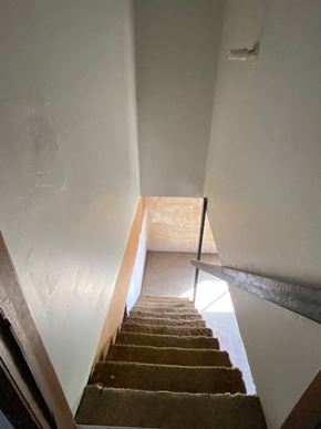 Knob Noster house for rent - A staircase with a carpeted runner and wooden steps.