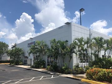 Doral apartment for rent - a white building with palm trees in front of it