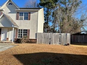 Jacksonville house for rent - A house with a white and beige exterior and a brown fence.